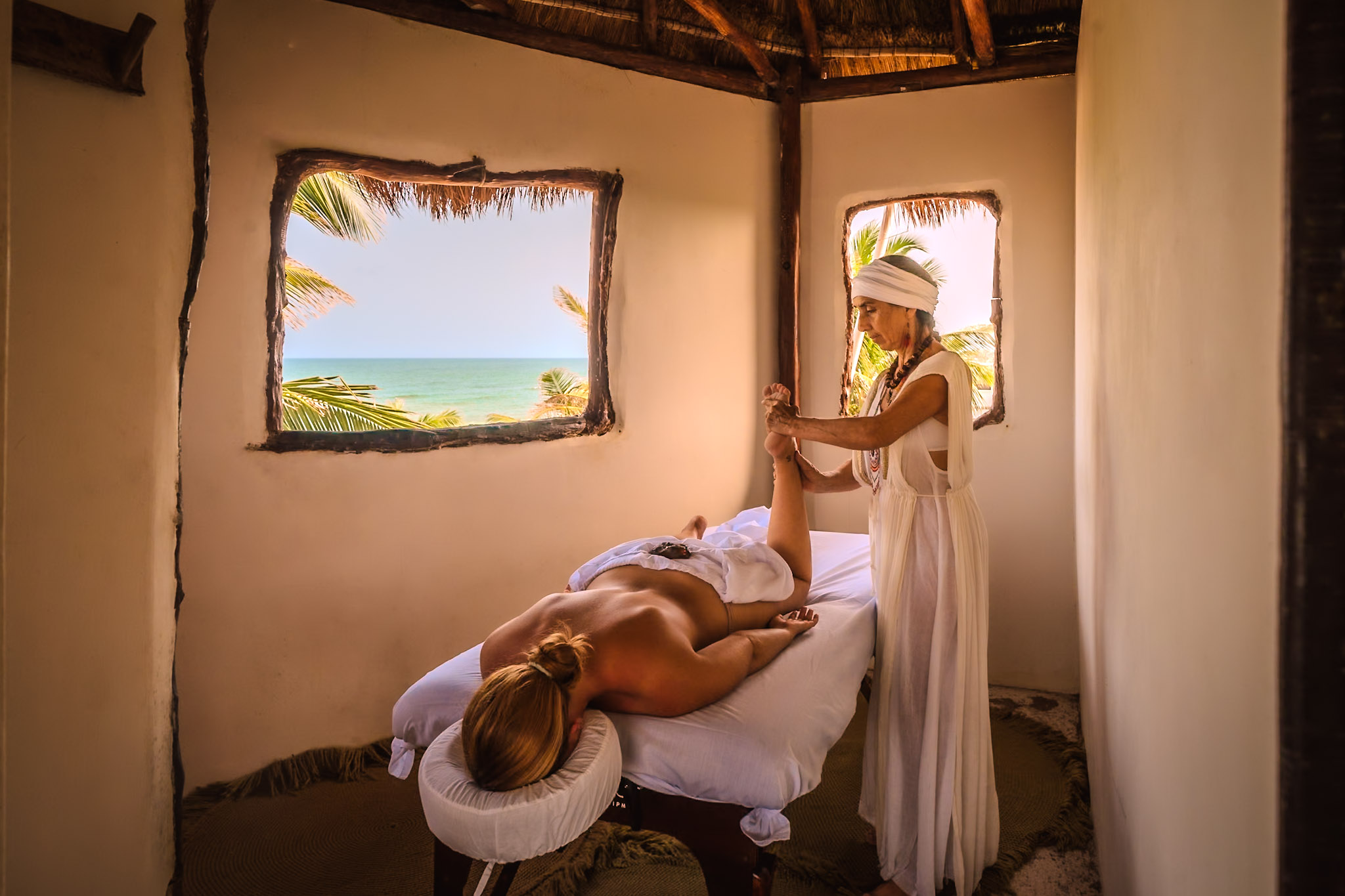Spa massage with ocean view through rustic windows
